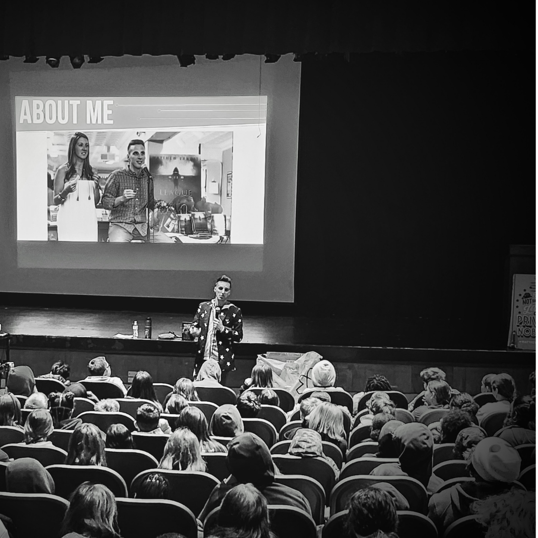 Matthew Landis on stage at auditorium assembly